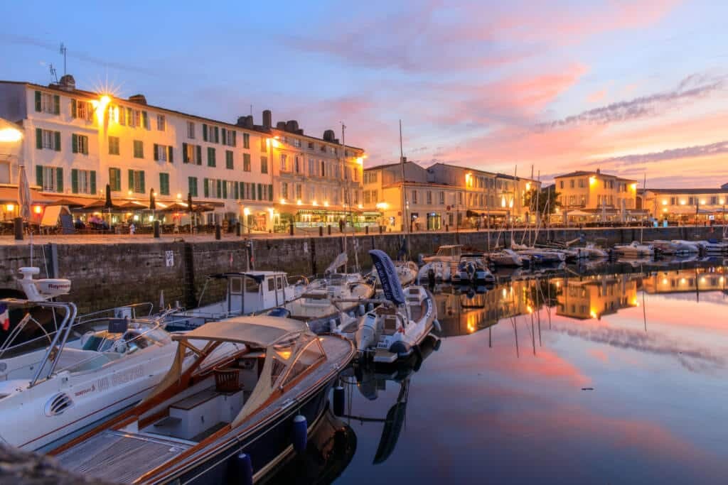 Quais et bateaux du port de Saint-Martin-de-Re illumines au coucher du soleil