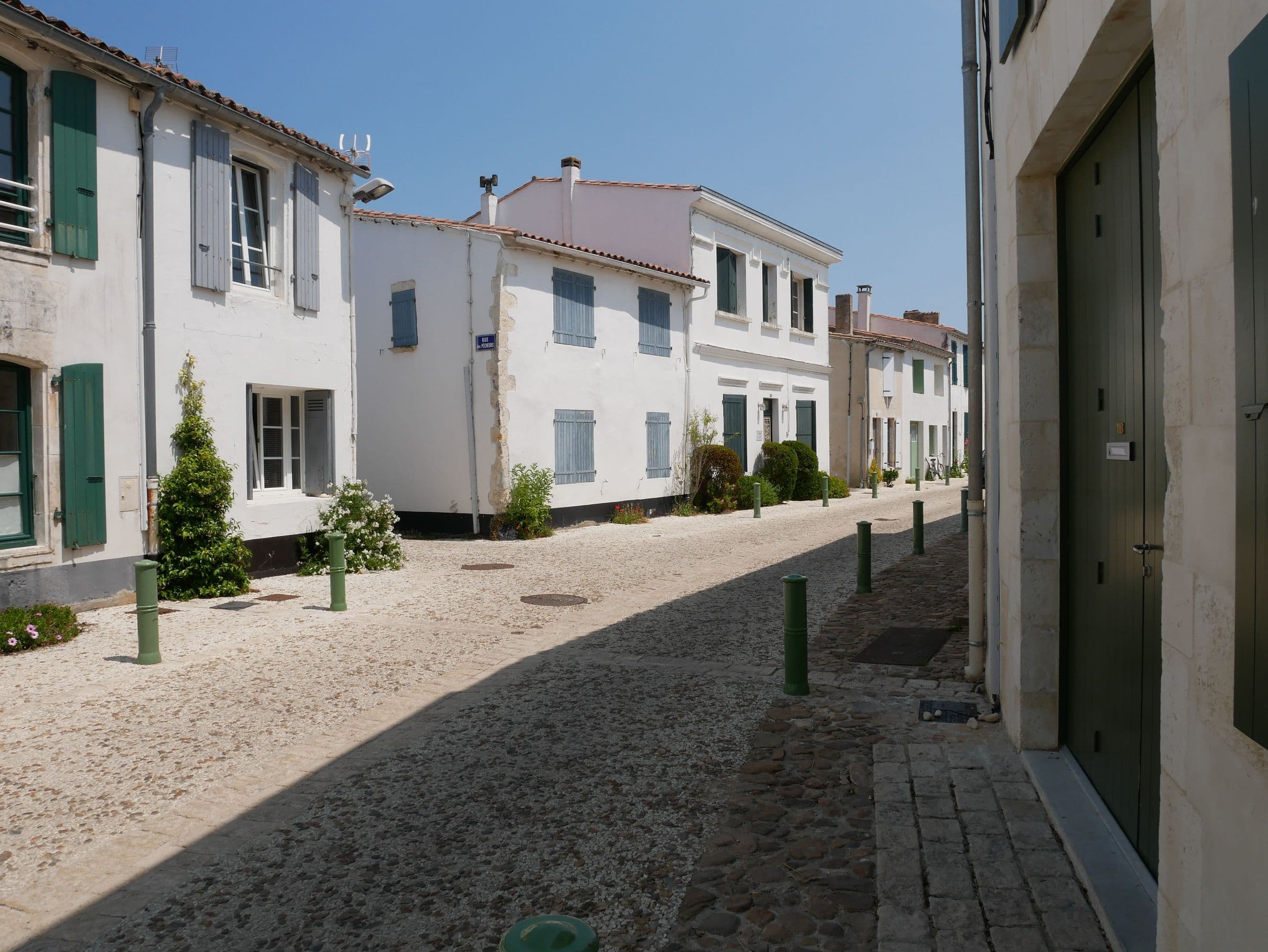 Ruelle pavee bordee de maisons blanches a volets sur l'Ile de Re