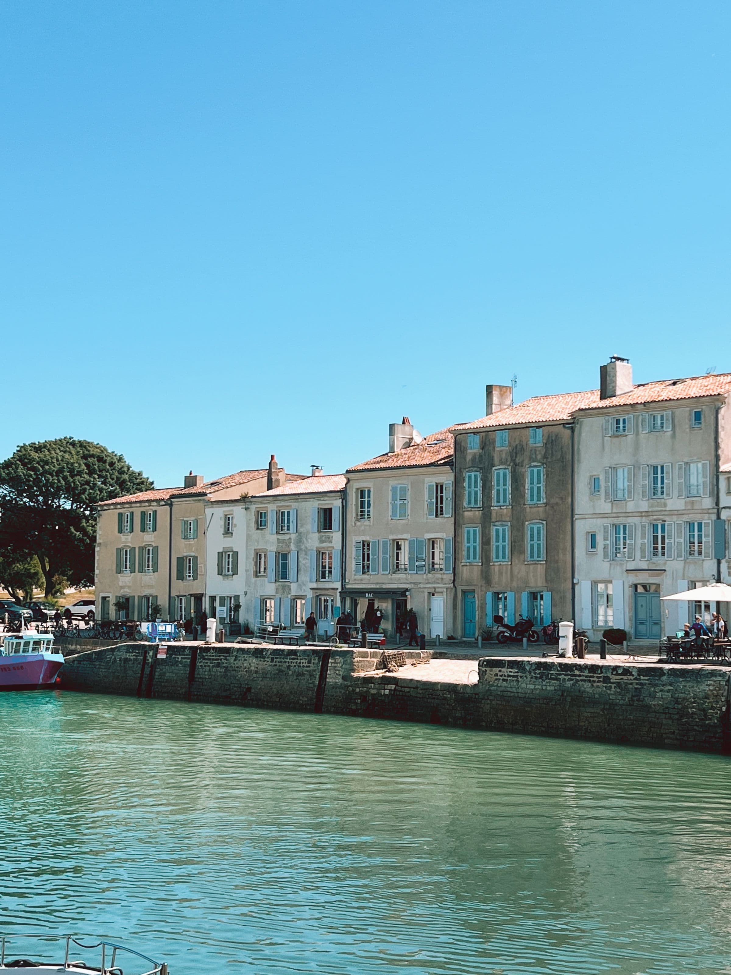 Maisons a volets colores bordant le quai d'un port de l'Ile de Re